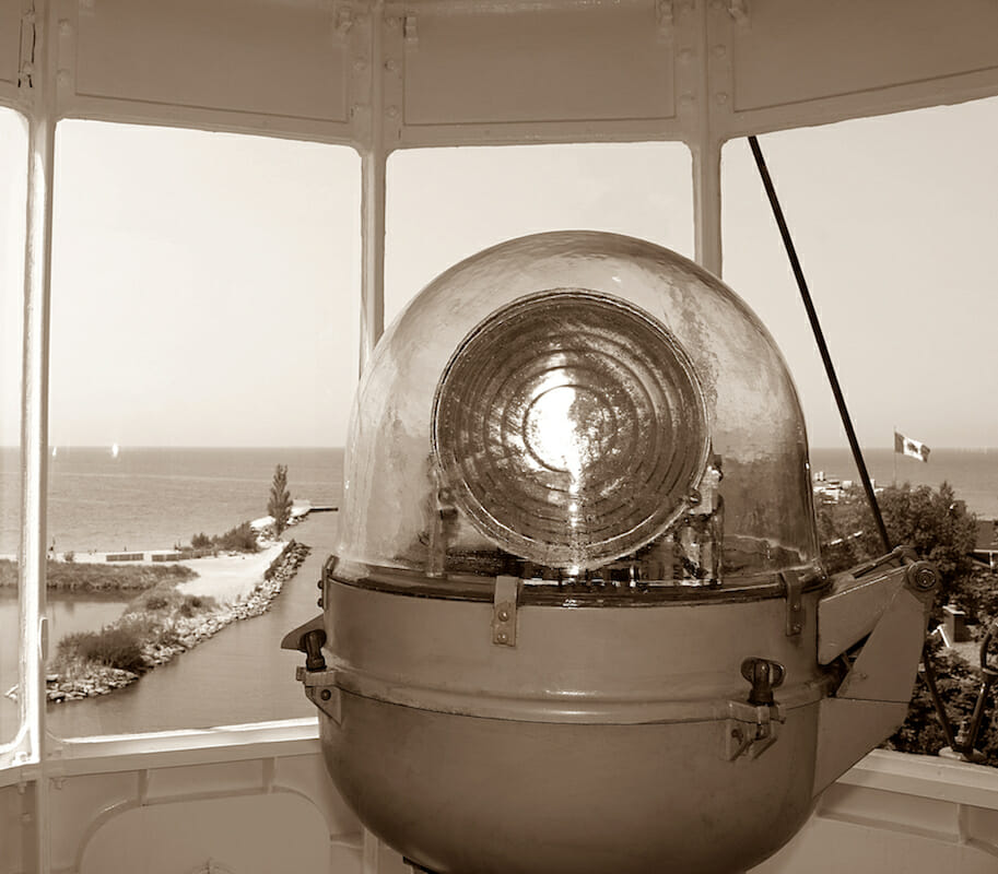 old lighthouse lamp from inside Kincardine, Ontario looking out windows to Lake Huron and the harbor